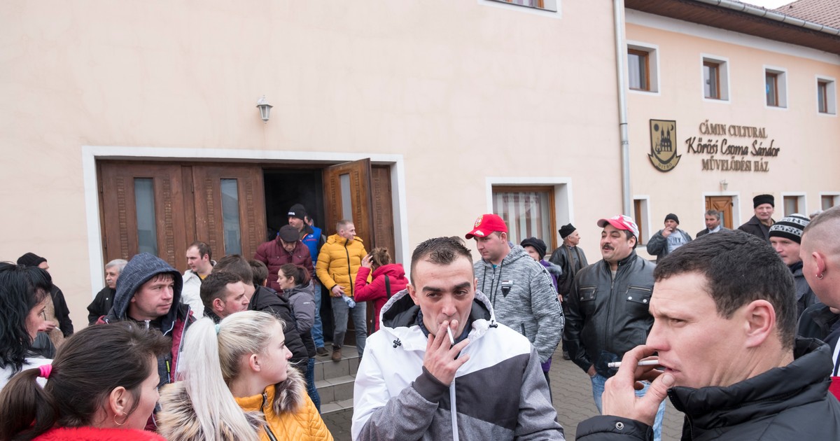 Zeci de locuitori ai comunei Ditrău vorbesc în fața căminului cultural după terminarea adunării sătești