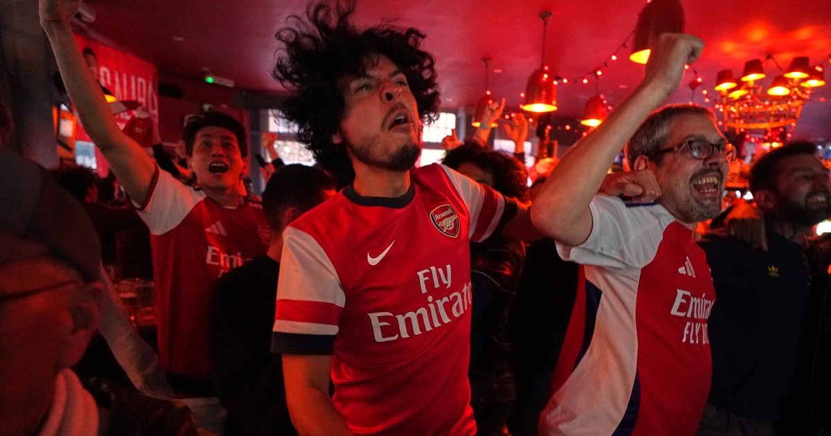 Suporterii echipei Arsenal sărbătoresc în timp ce urmăresc meciul din Premier League dintre Bournemouth și Manchester City într-un pub situat lângă stadionul echipei Arsenal din Londra, marți, 19 mai 2026.