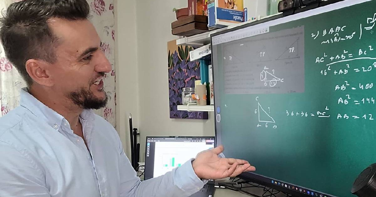 profesor care se afla in fata unui monitor si rezolva exercitii la matematica