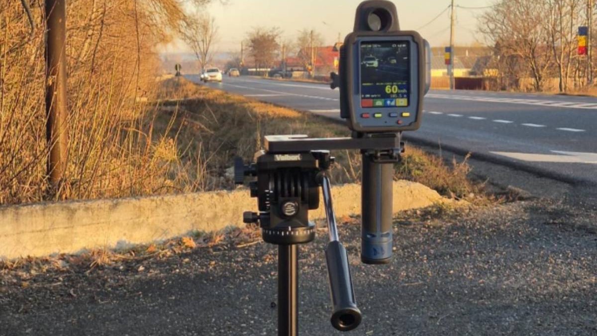 radar auto pus pe un trepied pe marginea drumului, pe fundal sunt cateva masini