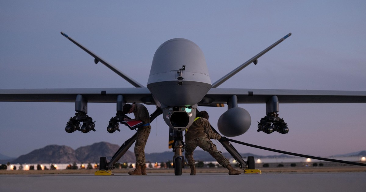 Personalul de întreținere al Gărzii Naționale Aeriene a SUA adnotează cablul de alimentare cu energie și încărcare a rachetei AGM-114 Hellfire către aeronava MQ-9 Reaper