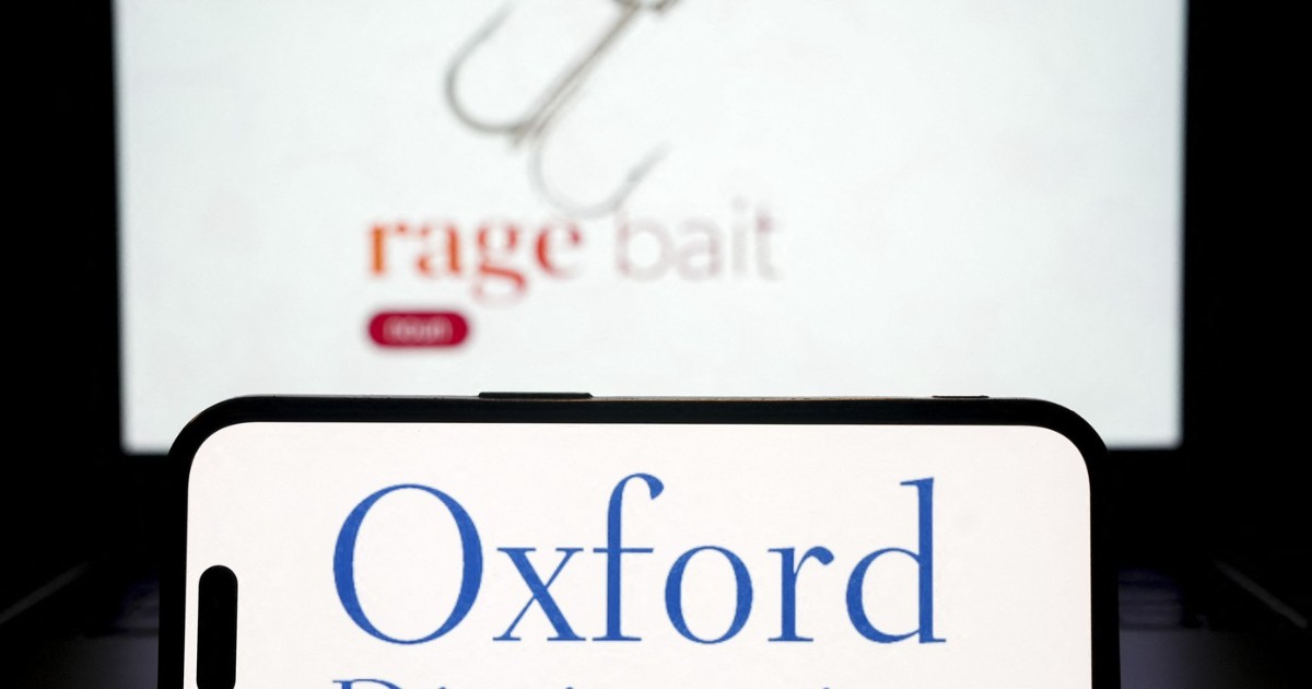 Imaginea arată un telefon mobil pe al cărui ecran apare sigla „Oxford Dictionaries”, clar evidențiată în prim-plan. În fundal, ușor estompat, se vede termenul „rage bait” alături de o iconiță cu un cârlig, sugerând conceptul de conținut menit să stârnească furie.