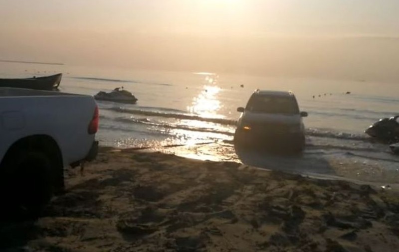 Mașină blocată pe plajă, la Năvodari. Un șofer se chinuie să o scoată din apă cu un alt autovehicul