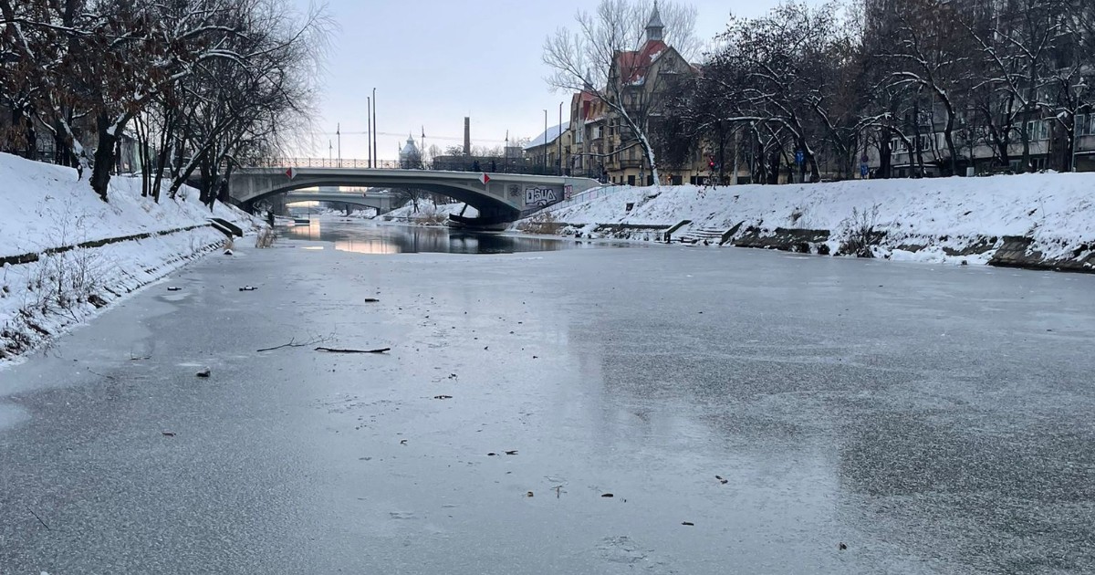 Stratul de gheață de pe Canalul Bega din Timișoara s-a format deasupra apei, se văd porțiuni mici unde s-a mai topit, iar malurile râului sunt acoperite de zăpadă