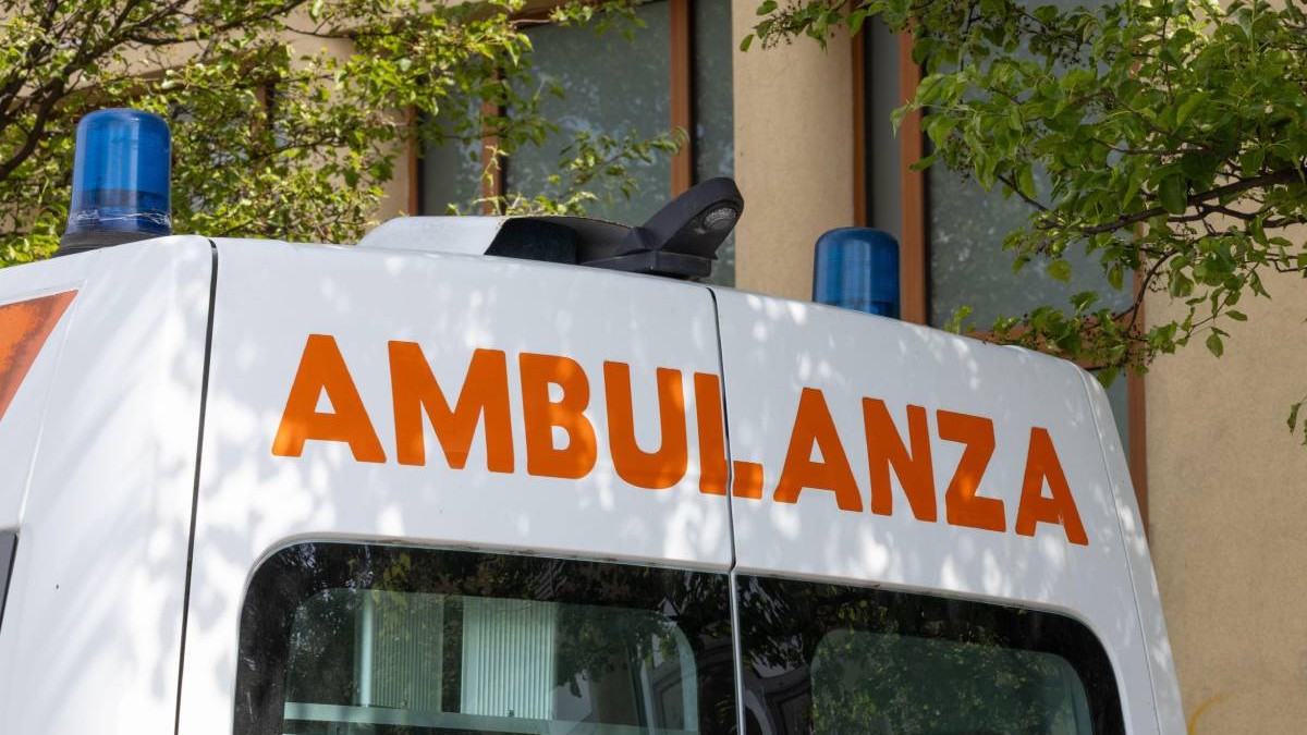 Ambulanță italiană cu litere portocalii parcată lângă o unitate medicală