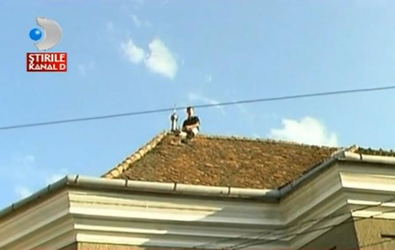 SPIDERMAN ar fi invidios! Protestatarul din Cluj care s-a urcat pe acoperișul BISERICII și a folosit CRUCEA drept cuier! VIDEO