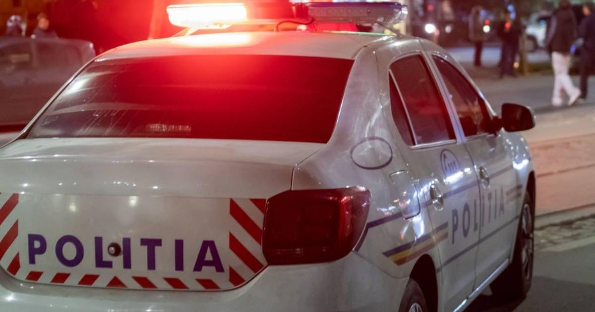 Masina de politie , vazuta din spate, cu lumini rosii aprinse