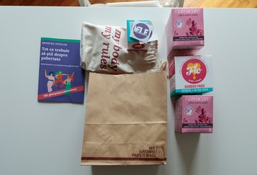 Pachetul pe care Asociația Iele Sânziene îl oferă fetelor la finalul atelierelor: tampoane, absorbante biodegradabile și reutilizabile, o broșură și stickere. Foto: Vlad Chirea