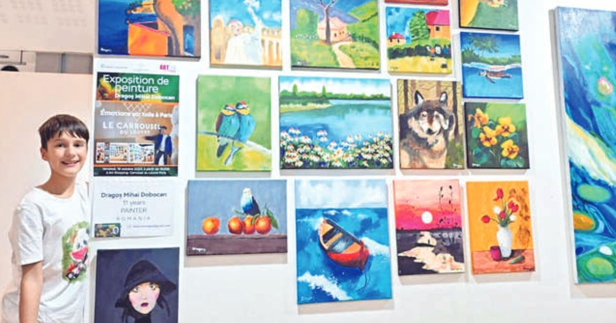 Imagine cu un tânăr artist, Dragos Mihai Dobocan, alături de picturile sale în cadrul unei expoziții