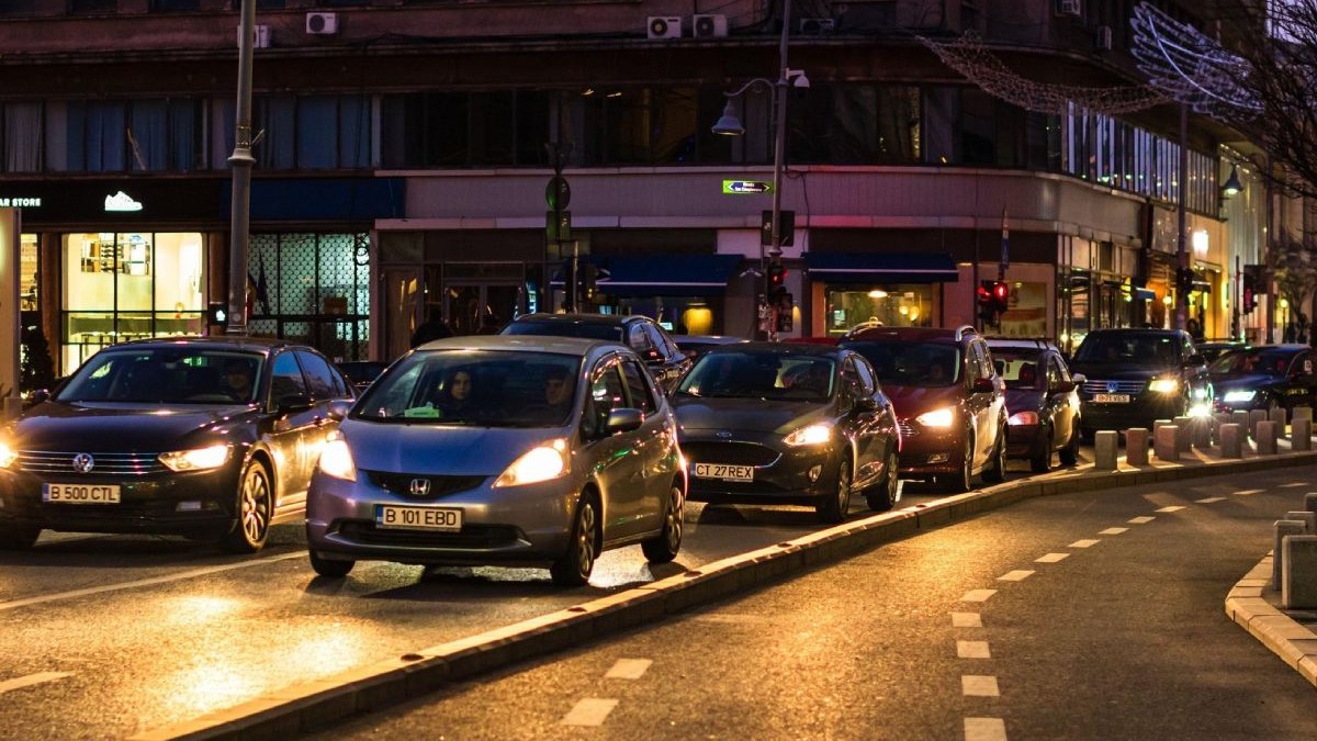 Mașini în traficul din București, noaptea, cu farurile aprinse, în timp ce așteaptă la semafor