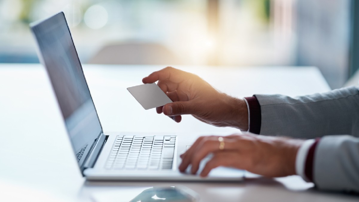 Un om de afaceri folosește laptopul și cardul de credit pentru cumpărături online