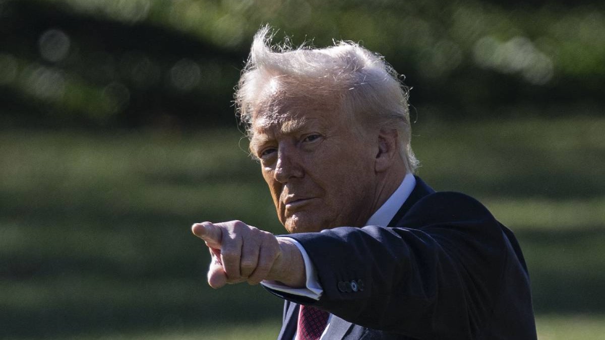 Donald Trump arată acuzator cu mâna spre cineva, poza este făcută în aer liber