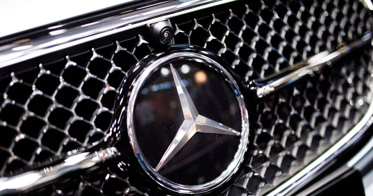 Prim-plan cu sigla mărcii Mercedes-Benz pe grila din față a unei mașini Mercedes