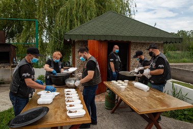 Membrii clubului pregătesc porţiile de mâncare pentru familiile nevoiaşe