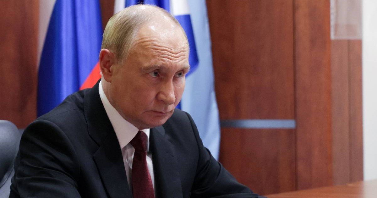 În imagine președintele Rusiei, Vladimir Putin, îmbrăcat în costum, așezat la birou, privește încruntat