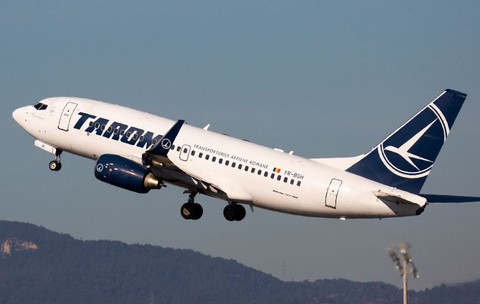 O fotografie a unui avion al companiei TAROM zburând.