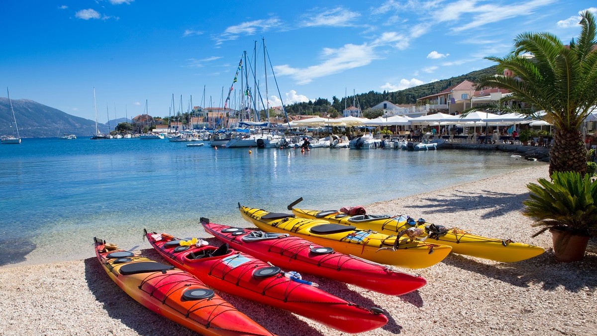 poza de pe plaja din Kefalonia, Grecia, cu 4 barcute gen caiac, 2 rosii si 2 galbene