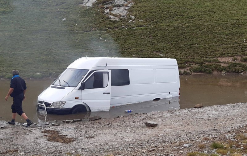 Microbuz plin cu turiști, blocat pe Transalpina într-o zonă cu apă și nămol