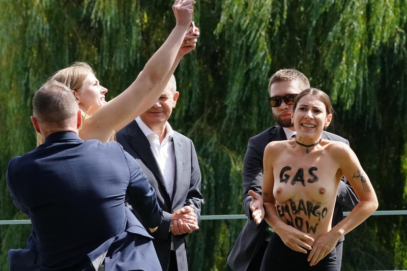 Forțele de ordine le îndepărtează pe cele două activiste care protestau lângă cancelarul german Olaf Scholz Foto: EPA