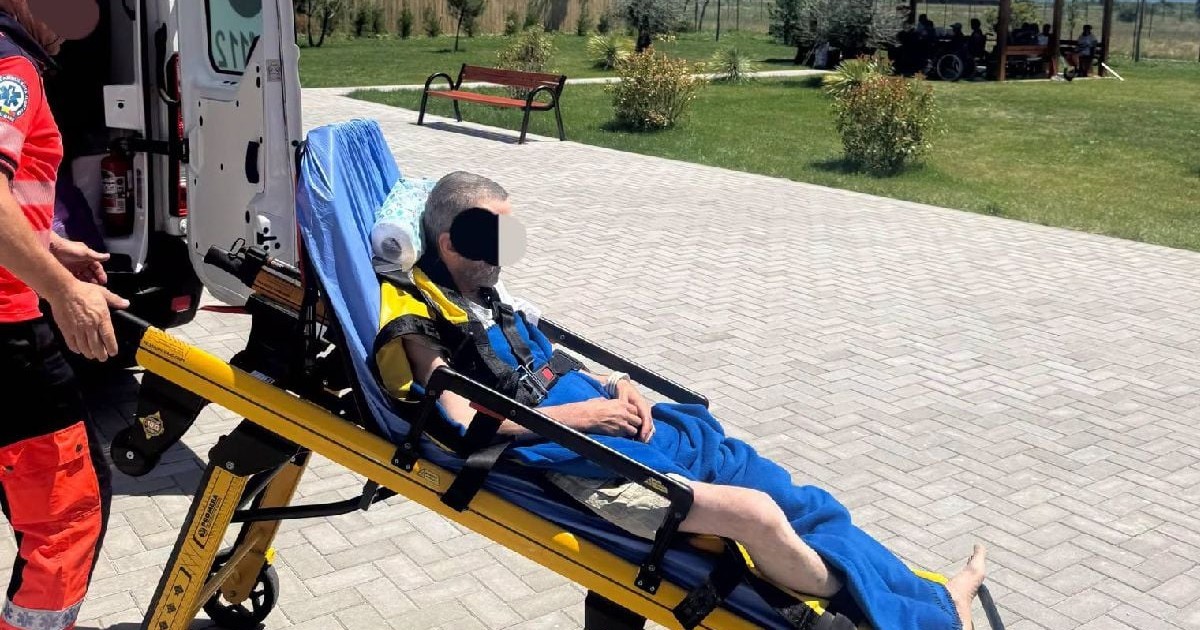 Un pacient pe o targă e coborât dintr-o ambulanță