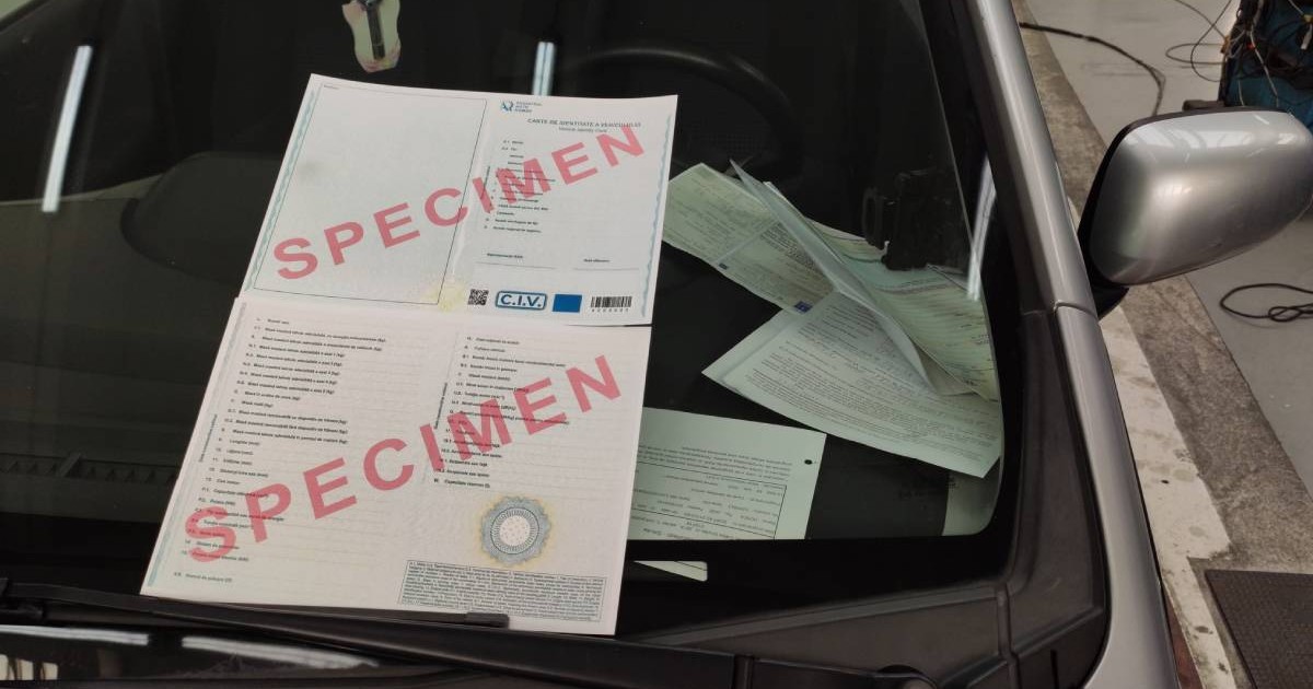 carte de identite a masinii pusa in parbrizul unei masini gri