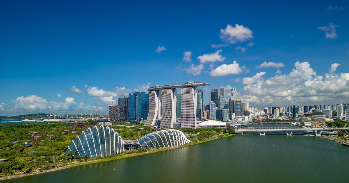 Clădiri zgârie-nori din Singapore, pe malul unei apei.