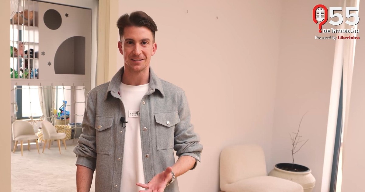 Rareș Cojoc, intr-o camasa de blugi purtata peste un tricou alb, la el in casa, in picioare