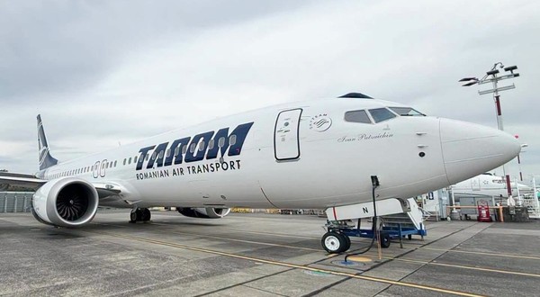 O aeronavă albă TAROM (cu numele de botez „Ivan Patzaichin” inscripționat în partea din față) staționată pe pista unui aeroport.