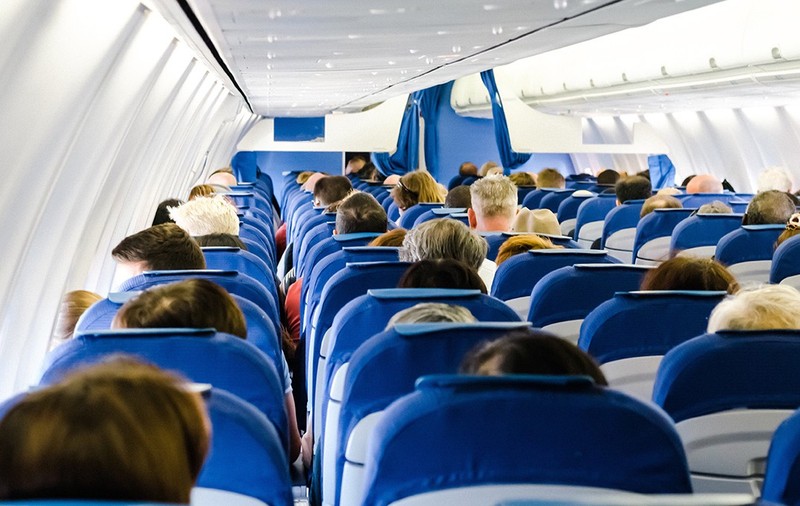 Imagine din interiorul unui avion cu scaunele pline de oameni