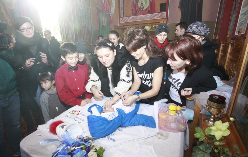 FOTO-REPORTAJ: Abandonat de mamă, s-a ales cu zeci de părinți spirituali. Bebelușul lăsat în ger a fost botezat