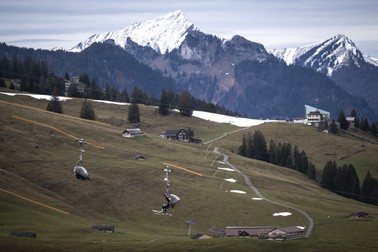 Un schior în telescaun, într-un peisaj lipsit de zăpadă din stațiunea Wildhaus din Elveția Foto: EPA