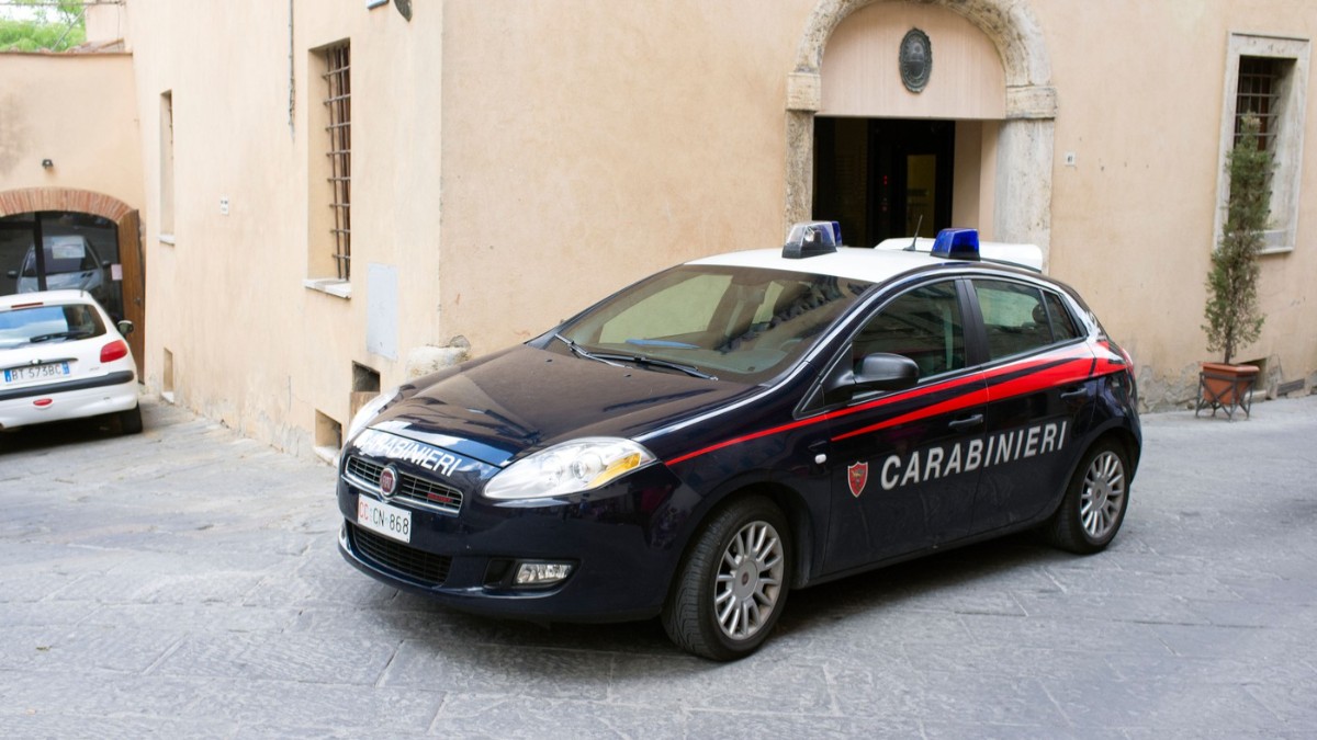 O mașină de carabinieri parcată în fața unei locuințe.