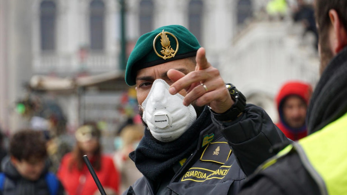 Un ofițer poartă mască de protecție în timpul carnavalului de la Veneția, care a fost scurtat din cauza coronavirusului | Foto: EPA