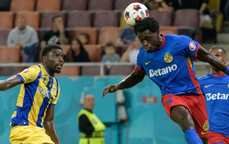 Breston Malula, în stânga, sare la cap în duel pentru balon cu Joyksim Dawa, de la FCSB