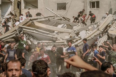 People gather around a building demolished by Israeli airstrikes to rescue injured civilians and retrieve bodies from the rubble. Israel escalated airstrikes across the Gaza Strip on Tuesday, crushing families in the rubble of residential buildings, as health officials said hundreds of Palestinians were killed in the past day and medical facilities were shut down because of bomb damage and lack of power. The soaring death toll from the bombardment is unprecedented in the decades-long Israeli-Palestinian conflict. Photo by Saher Alghorra/Middle East Images/ABACAPRESS.COM