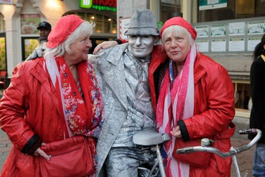 TO GO WITH AFP STORY BY JAN HENNOP Twins Louise (L) and Martine (R) Fokkens, 70, pose with a street artist ain the centre of Amsterdam on November 15, 2012, the Netherlands. Twins Martine and Louise Fokkens, nicknamed the 'Queens of the wallen', are Amsterdam's oldest prostitutes, having worked for fifty years in the city's red-light-district, and they have wrote two books about their experiences.,Image: 147295981, License: Rights-managed, Restrictions: TO GO WITH AFP STORY BY JAN HENNOP, Model Release: no