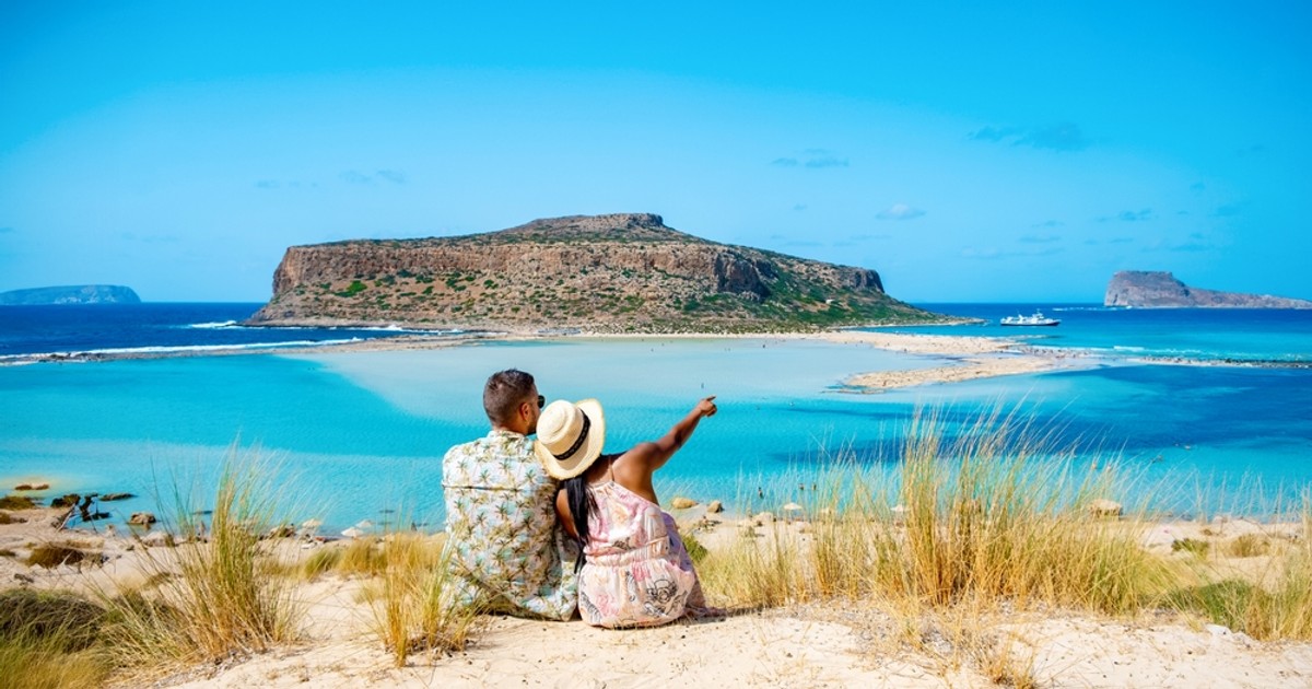 Unde să mergi la mare în octombrie, în Europa - Imagine cu doi turişti care admiră de la înălţime plaja Balos din Creta
