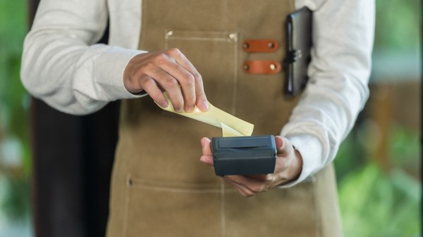 Un chelner care scoate nota de plată