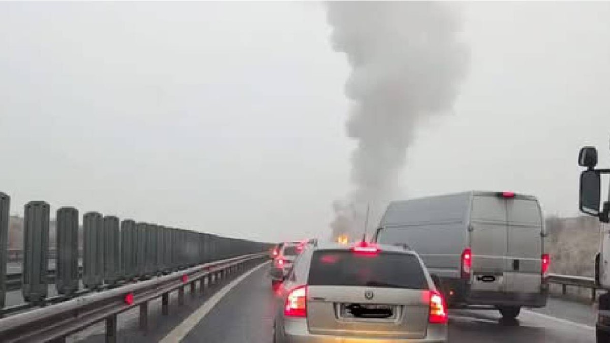 o coloană de fum se vede pe Autostradă și mai multe mașini sunt staționate