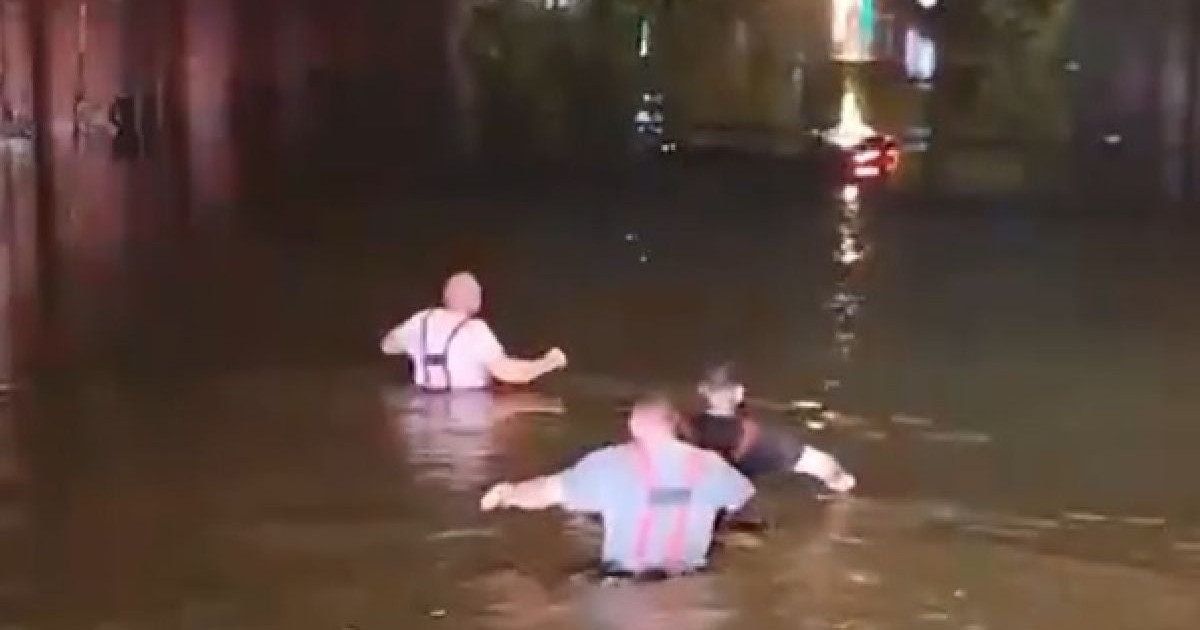 Trei pompieri intrați până la brâu în apă, într-un pasaj rutier inundat, în București