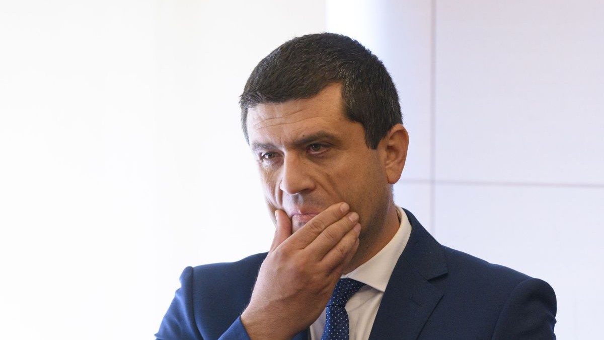 Radu Miruță, gânditor, duce mâna dreaptă la față, iunie 2025