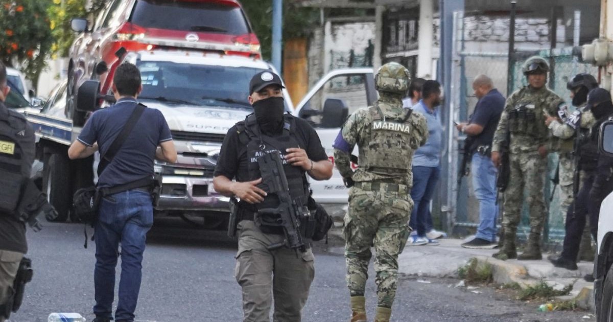 Membri ai parchetului general și ai Marinei stau de pază în apropierea unui vehicul implicat într-un schimb de focuri în Veracruz, Mexic