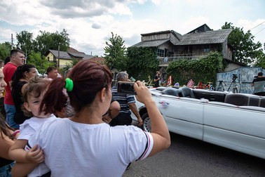 O femeie fotografiază cu telefonul mobil casa lui Gh. Dincă