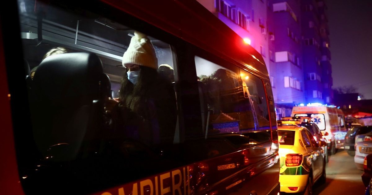 Un echipaj SMURD în prim-plan, iar pe fundal mașini de Poliție și Ambulanță, noaptea, cu girofarele pornite