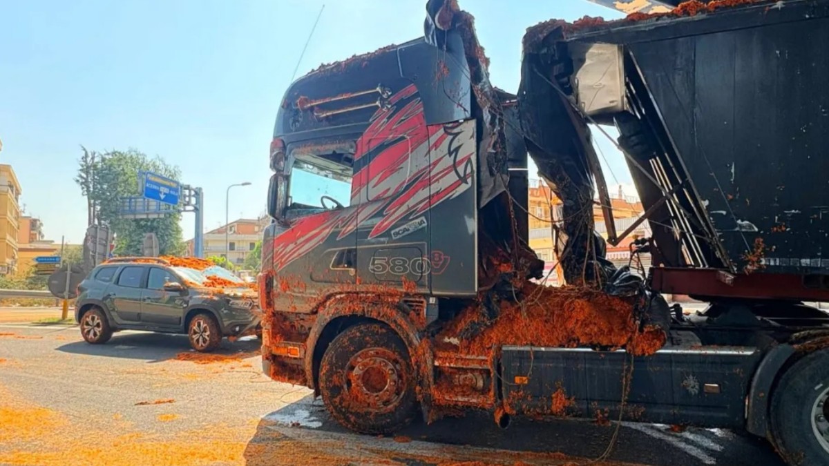 Imaginea prezintă urmările unui incident rutier în care un camion și un autoturism Duster au fost acoperite de o cantitate uriașă de pastă sau încărcătură de roșii împrăștiată pe șosea.