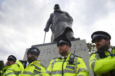 Mai mulți polițiști stau în fața statuii lui Winston Churchill din Londra, în timpul unui protest Black Lives Matter | Foto: EPA