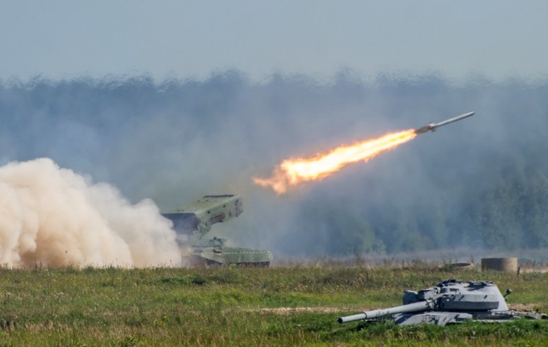 Momentul lansării unei rachete dintr-un sistem militar autopropulsat pe un câmp, lăsând în urmă o jerbă masivă de foc și fum alb dens.   