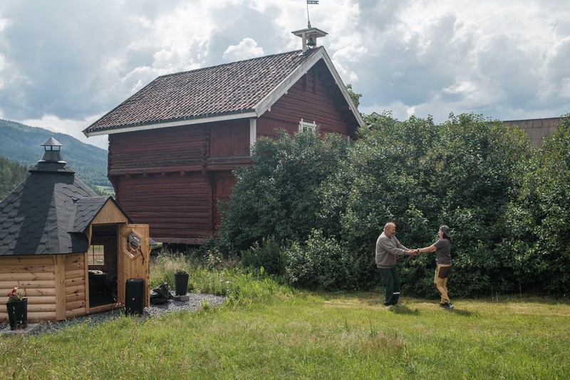 Oddvar și Roxana Stangebye dansează pe muzică norvegiană în curtea lor din Prestfoss, Norvegia, în timp ce în foișor se face carnea pe grătar. Foișorul a fost construit de Roxana.