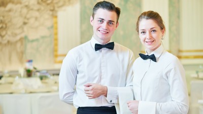 Ospătar si ospătăriță în cămașă albă și papion