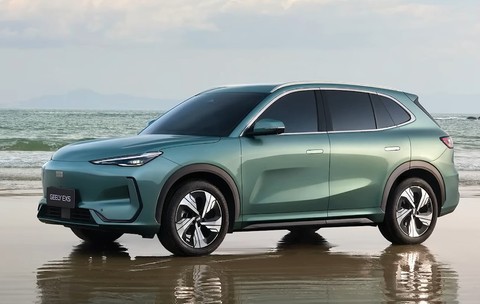 Imaginea prezintă hibridul Geely Starray EM-i  de culoare verde mentă parcat pe o plajă, pe un nisip umed care reflectă automobilul.